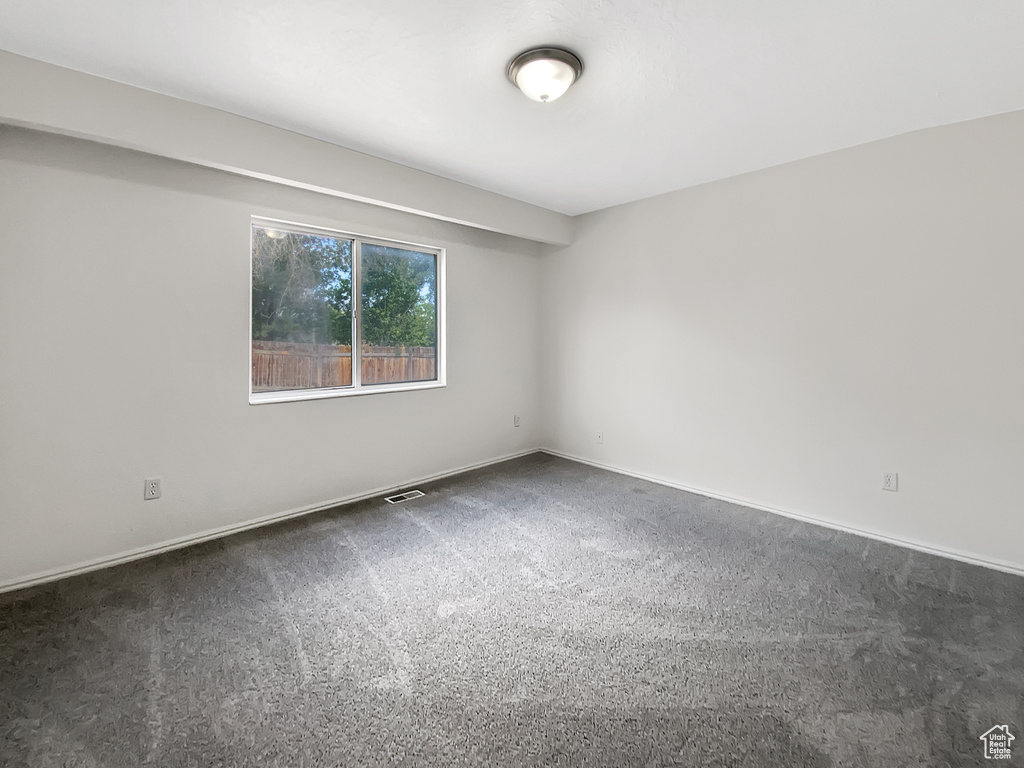 Carpeted spare room with baseboards