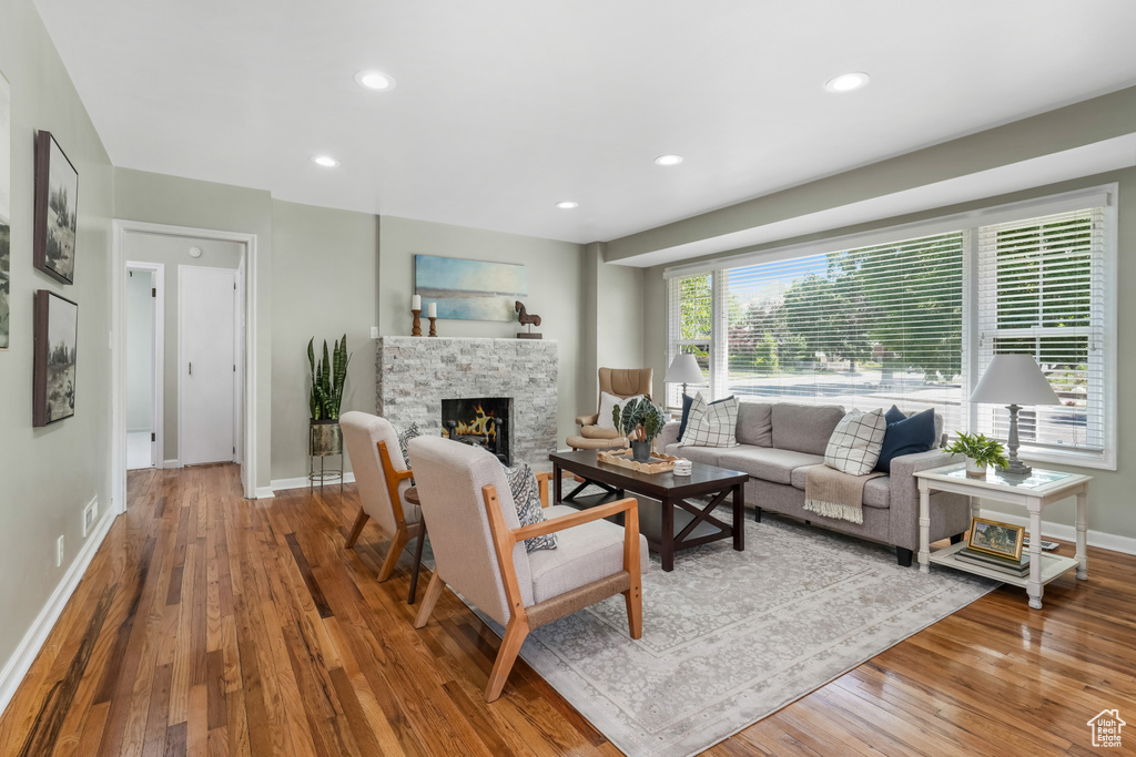Living room with hardwood / wood-style floors, a fireplace, and recessed lighting