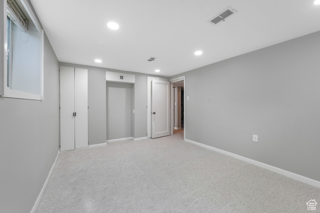 Unfurnished bedroom with recessed lighting and light carpet
