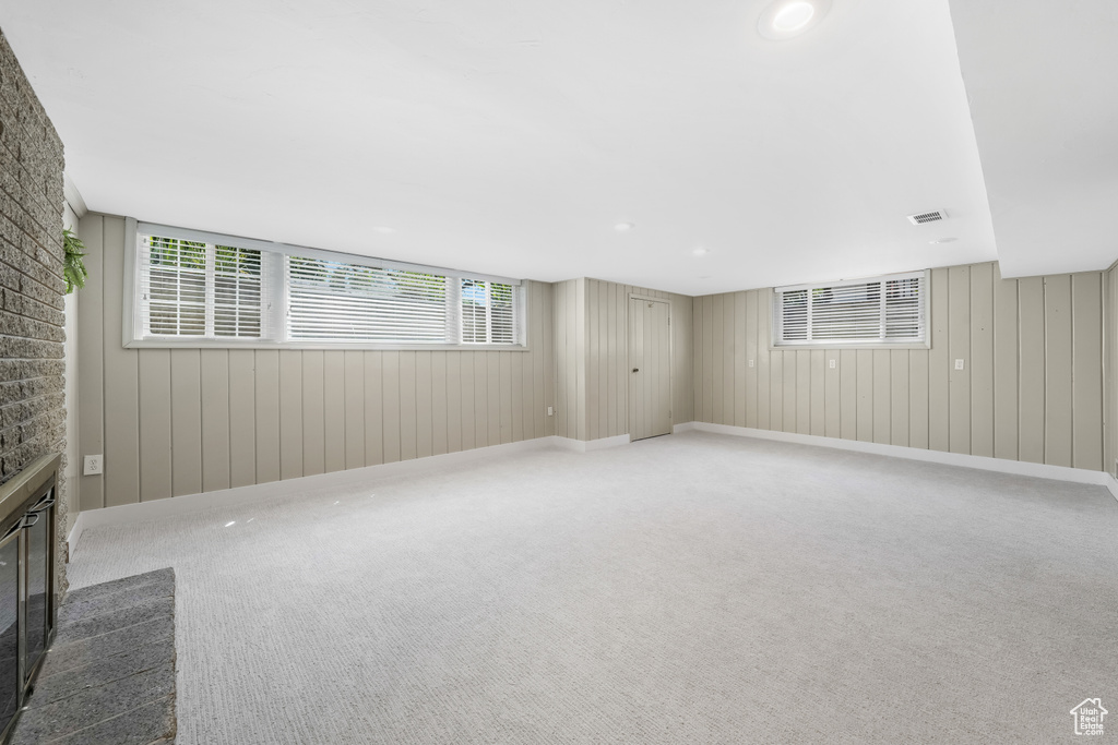 Unfurnished living room with carpet floors and a glass covered fireplace