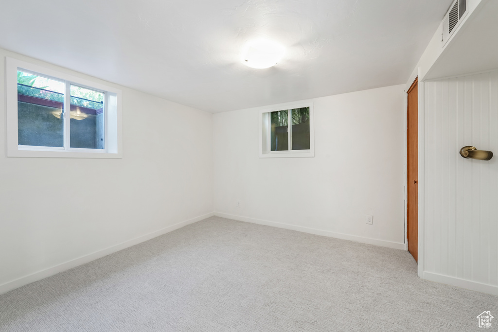 Empty room featuring light carpet and baseboards
