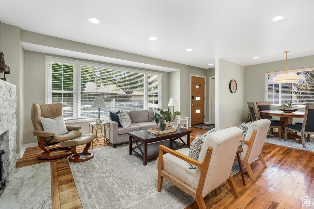 Living room featuring healthy amount of natural light, a fireplace, wood finished floors, and recessed lighting