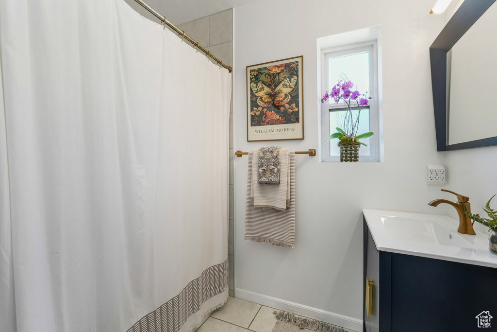 Bathroom featuring tile patterned floors, vanity, and a shower with curtain
