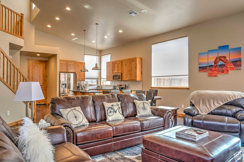 Living area with recessed lighting, stairs, and baseboards