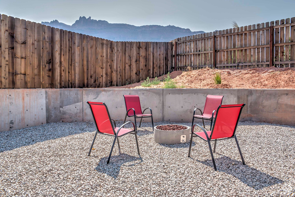 Fenced backyard featuring a mountain view, an outdoor fire pit, and a patio area