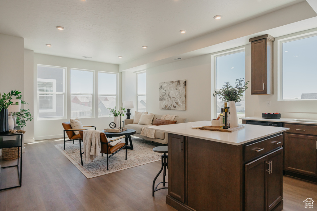 Kitchen featuring light countertops, dark wood-type flooring, dark brown cabinetry, and recessed lighting