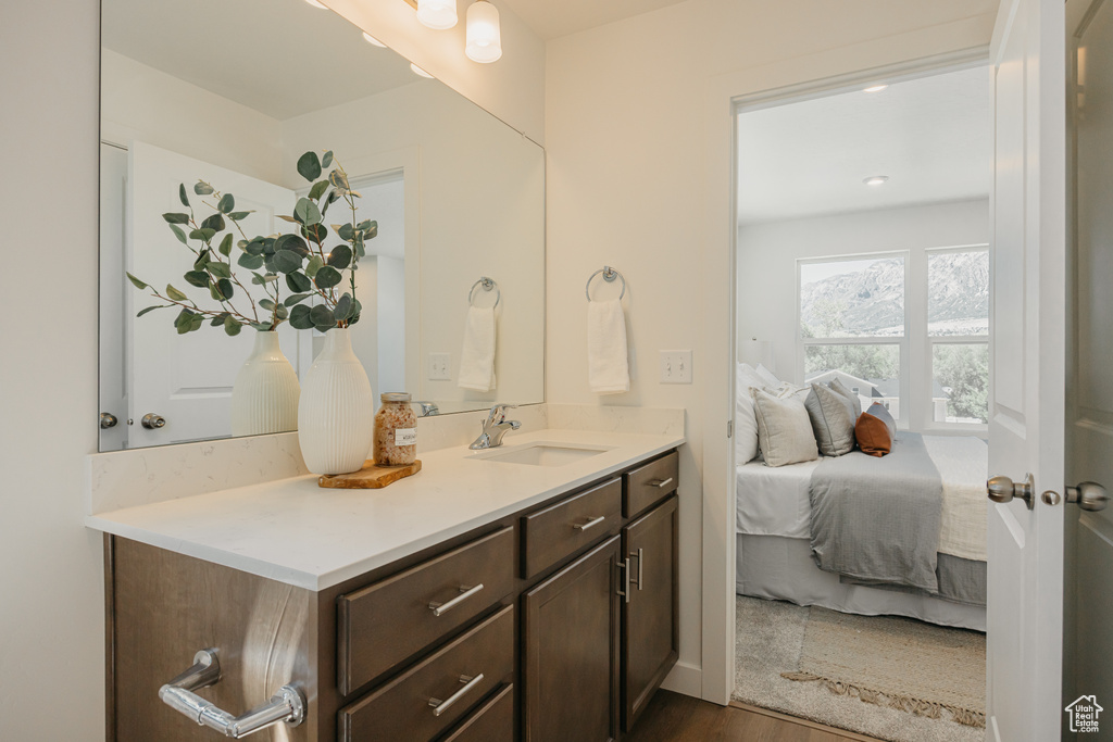 Bathroom with vanity, wood finished floors, and connected bathroom