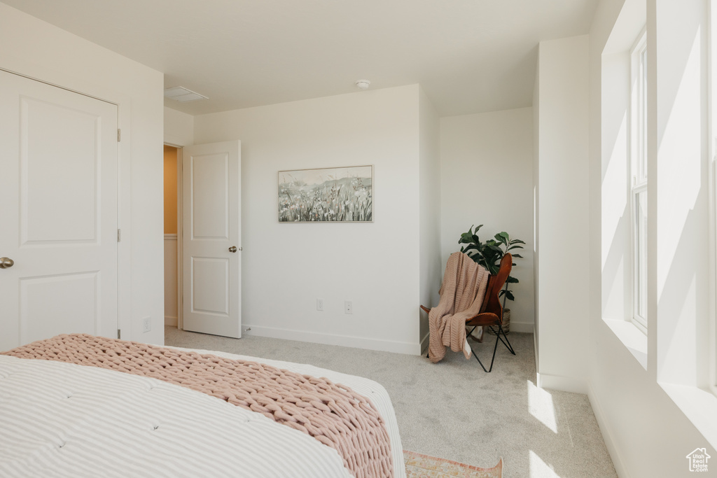 Bedroom with light carpet and baseboards