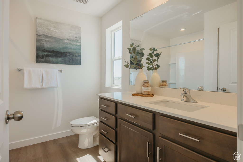 Full bathroom with vanity and wood finished floors