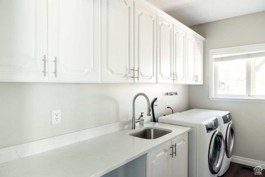 Washroom featuring cabinet space, separate washer and dryer, and dark wood-style floors