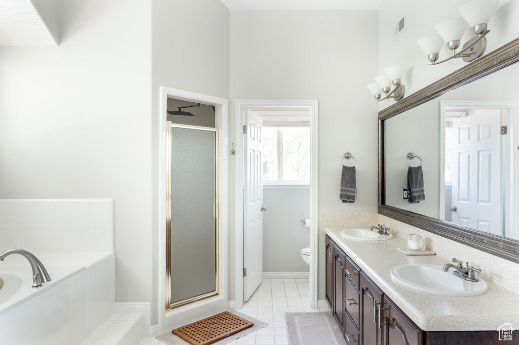 Bathroom featuring a shower stall, a garden tub, double vanity, and tile patterned flooring