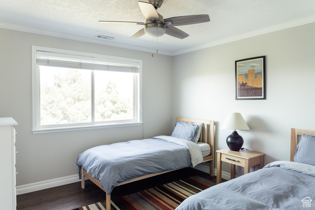 Bedroom featuring crown molding, wood finished floors, a ceiling fan, and a textured ceiling