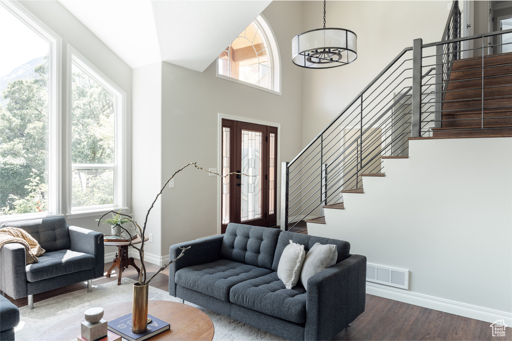 Living area with stairs, wood finished floors, and a chandelier