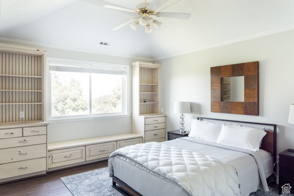 Bedroom with dark wood finished floors, crown molding, lofted ceiling, and ceiling fan