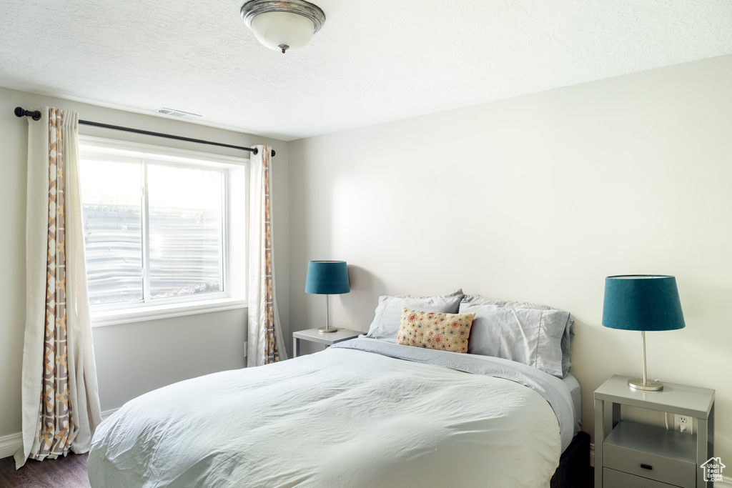 Bedroom featuring dark wood finished floors and a textured ceiling