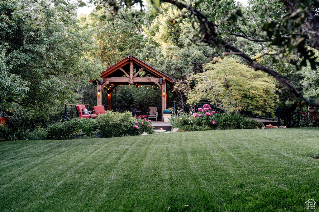 View of green lawn with a gazebo and a view of trees