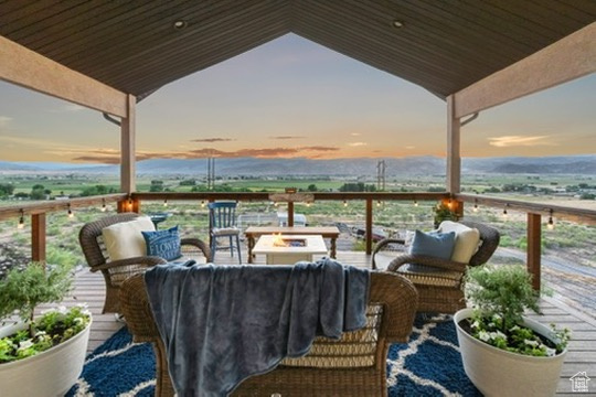 Deck at dusk featuring an outdoor living space with a fire pit