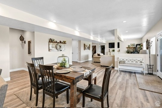 Dining space with light wood-style floors and recessed lighting