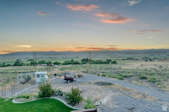 Yard at dusk featuring a view of rural / pastoral area