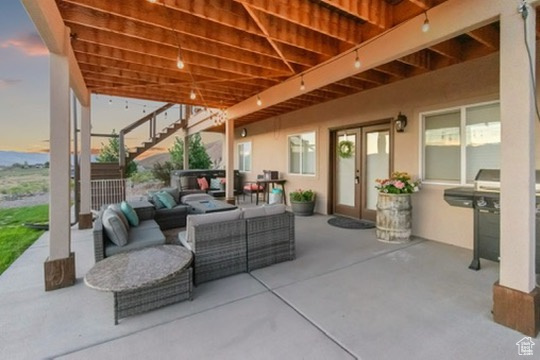 View of patio featuring outdoor lounge area, grilling area, stairway, and french doors