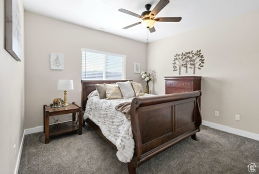 Carpeted bedroom featuring baseboards and a ceiling fan