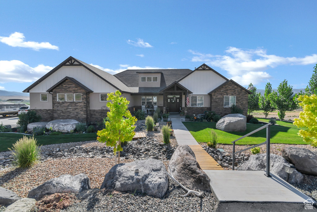 Craftsman inspired home with stone siding and a front yard