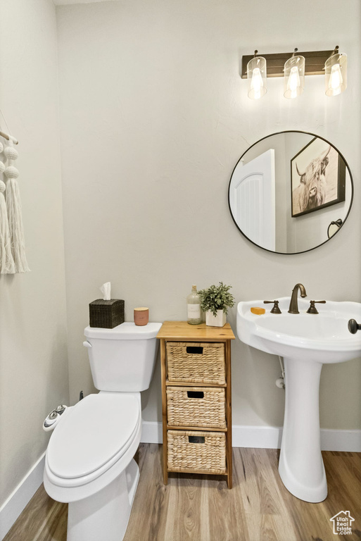 Half bathroom featuring wood finished floors and baseboards