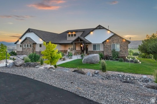View of front of home with stone siding and a front lawn