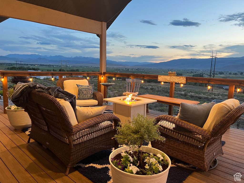 Wooden deck with an outdoor fire pit and a mountain view