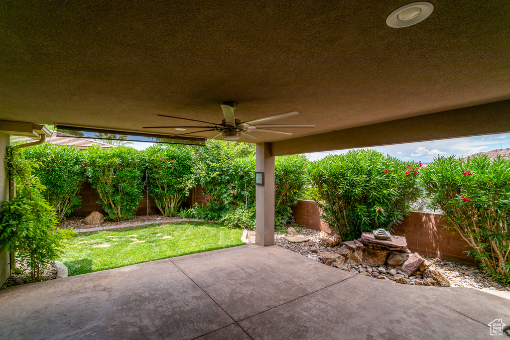 Fenced backyard featuring a ceiling fan and a patio area