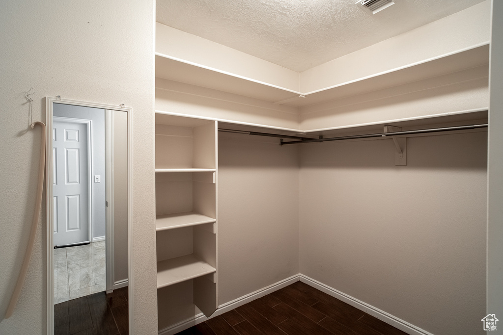 Walk in closet featuring dark wood finished floors