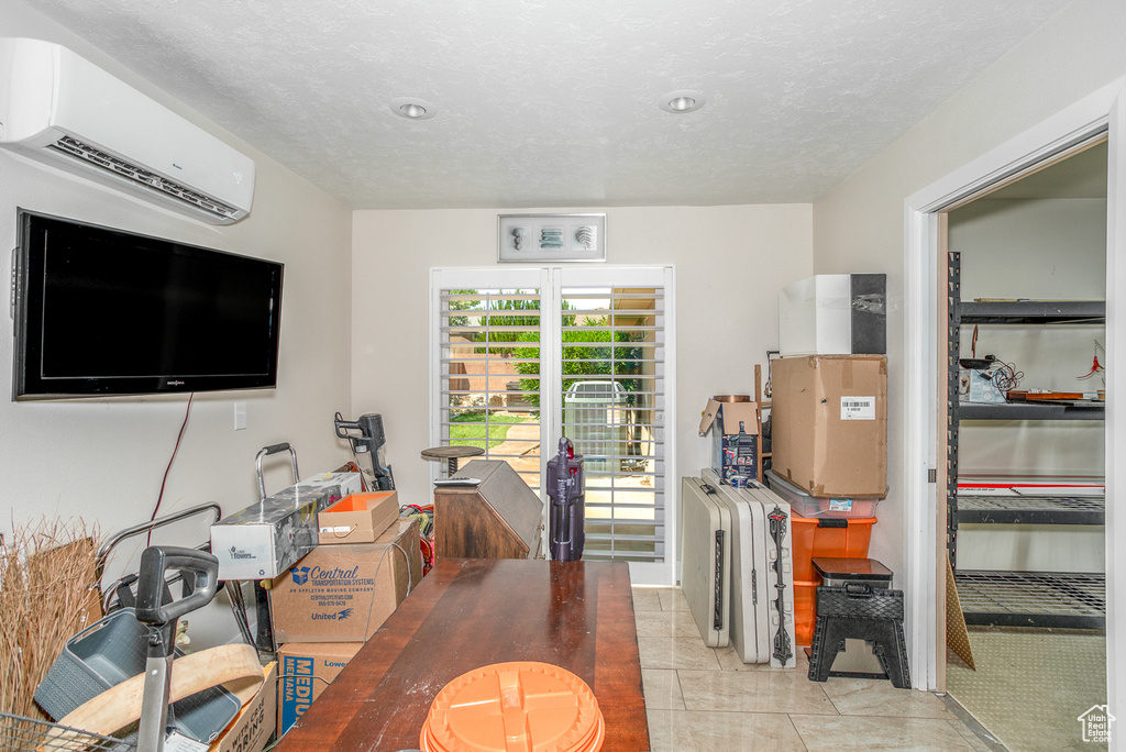 Office area featuring a wall unit AC and light tile patterned floors