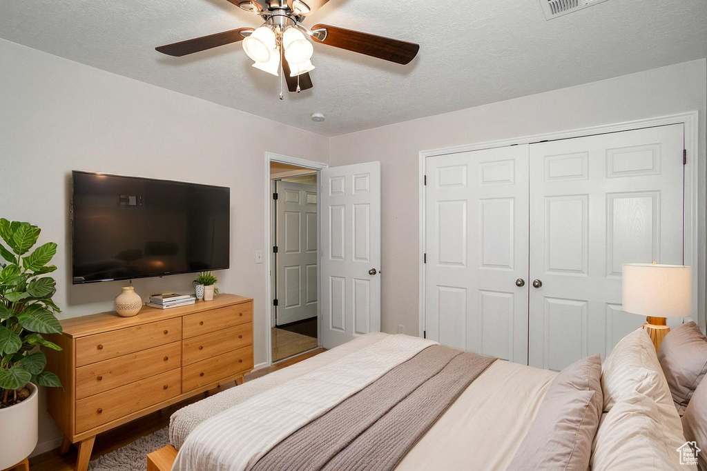 Bedroom featuring a closet, a ceiling fan, and wood finished floors