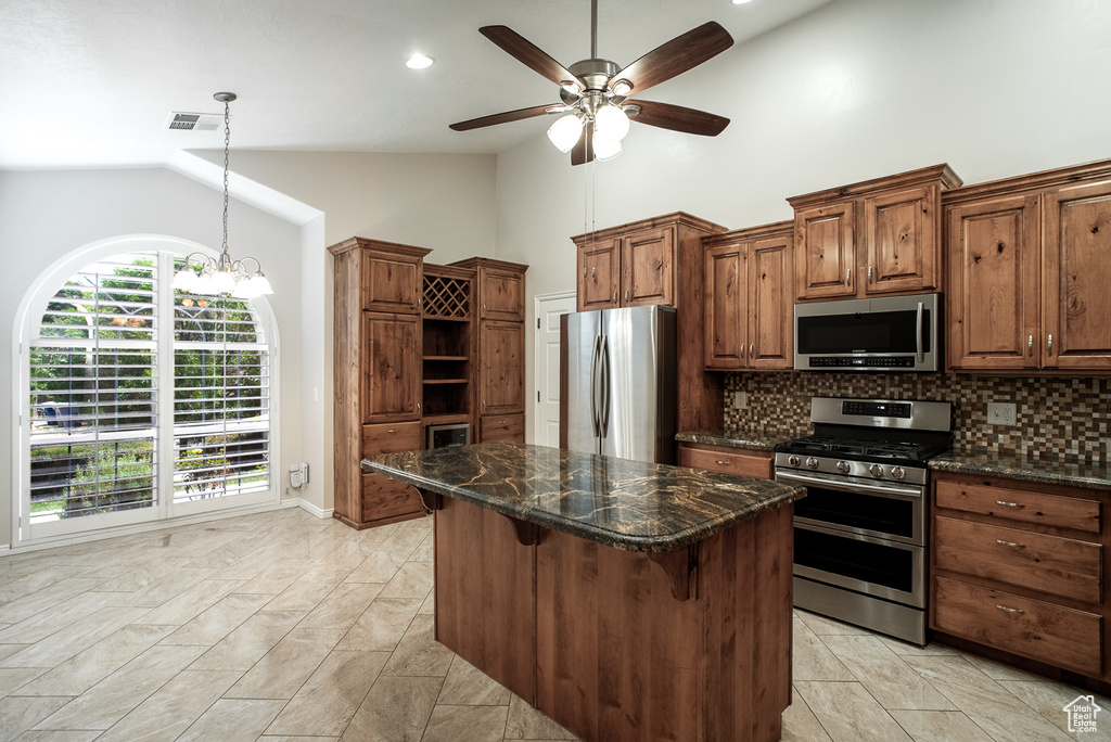 Kitchen featuring appliances with stainless steel finishes, ceiling fan, decorative backsplash, open shelves, and a center island