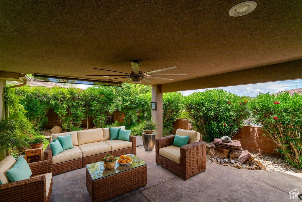 Fenced backyard with a patio, a ceiling fan, and an outdoor living space