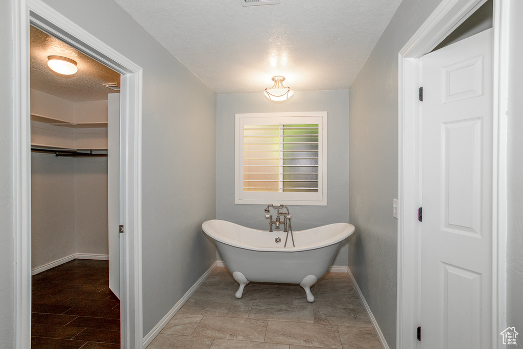 Full bathroom featuring baseboards and a freestanding tub