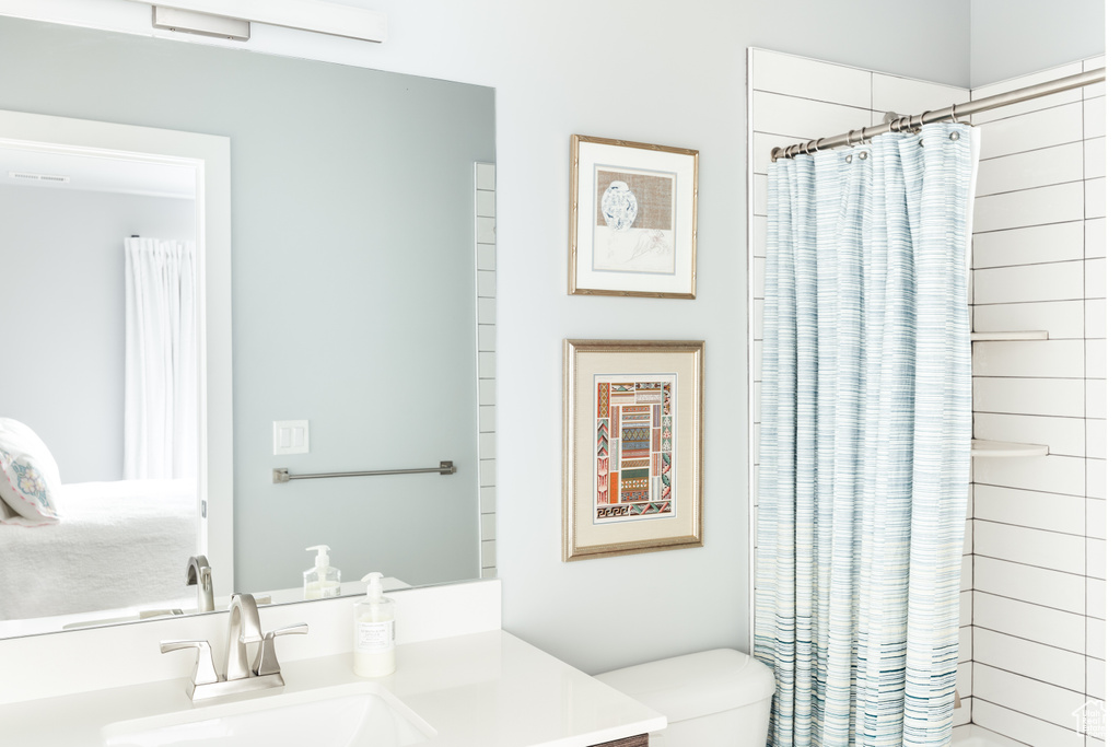Full bath with vanity, toilet, and curtained shower