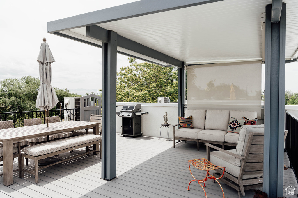 Wooden terrace with area for grilling, outdoor lounge area, and outdoor dining area