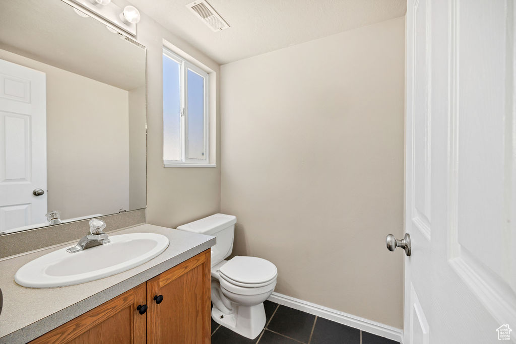 Half bathroom with vanity and tile patterned flooring