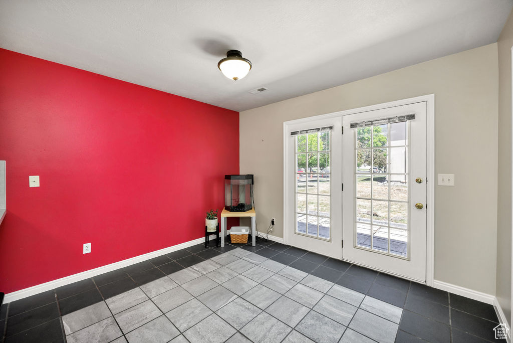 Unfurnished room with an accent wall and tile patterned floors