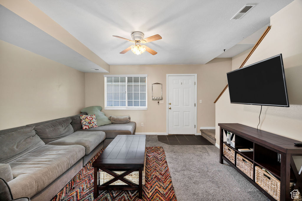 Living room with carpet and a ceiling fan