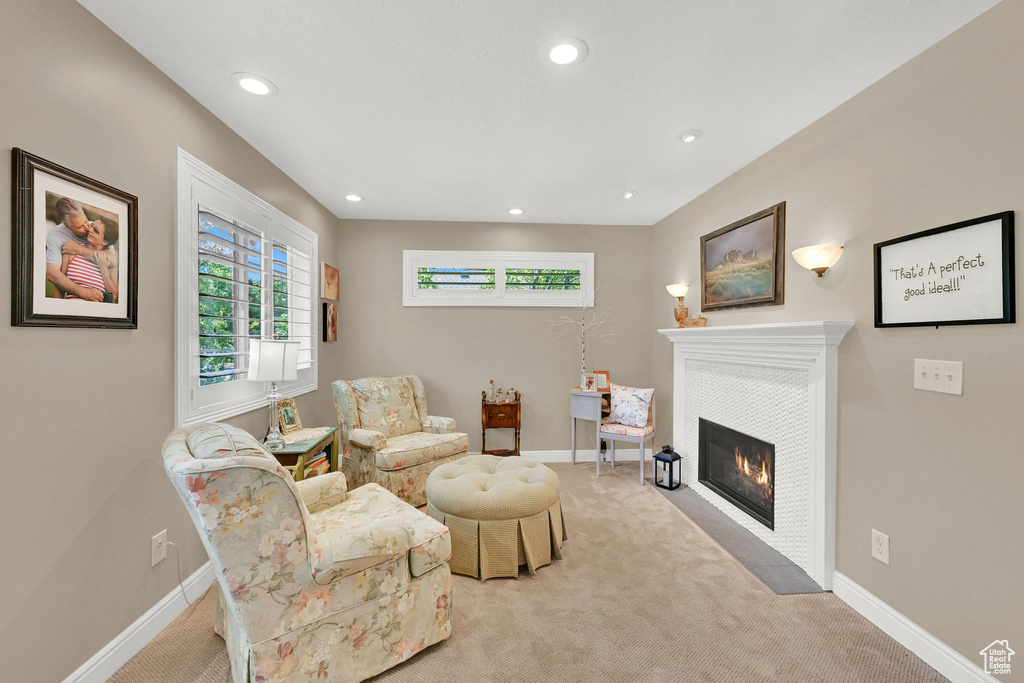 Living area with light colored carpet, recessed lighting, and a fireplace