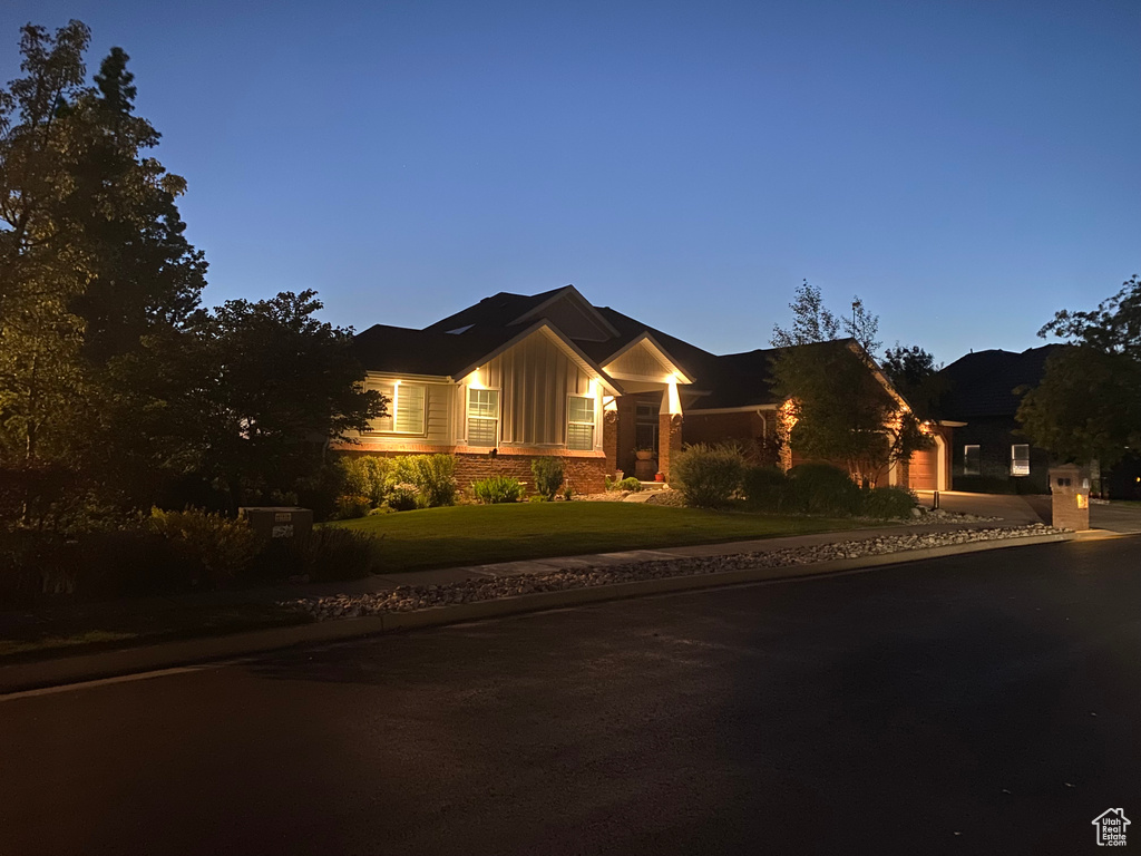 View of front of home with board and batten siding and a front yard