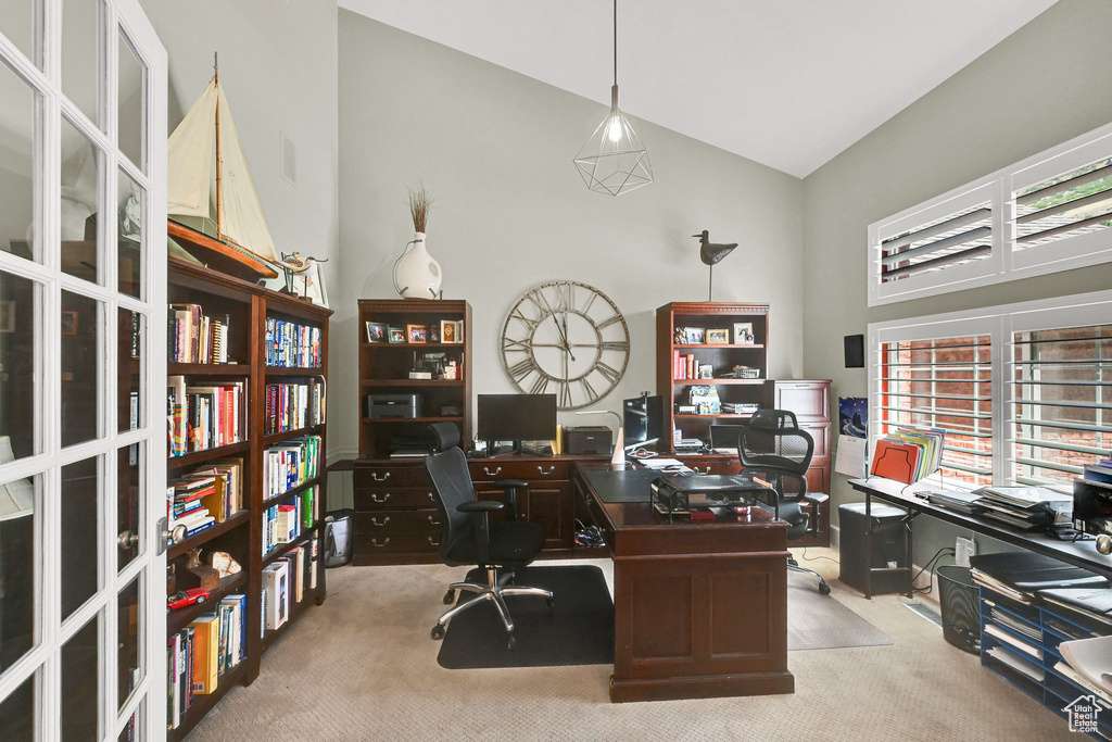 Carpeted home office featuring high vaulted ceiling