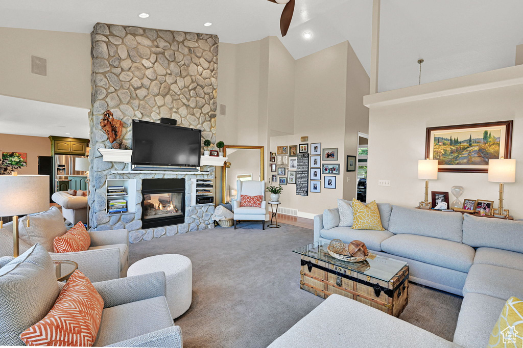 Living room with high vaulted ceiling, a fireplace, carpet floors, recessed lighting, and ceiling fan