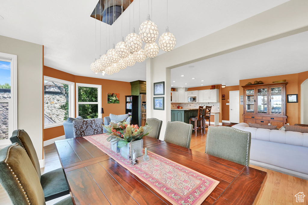 Dining space featuring light wood-style flooring, recessed lighting, and a chandelier
