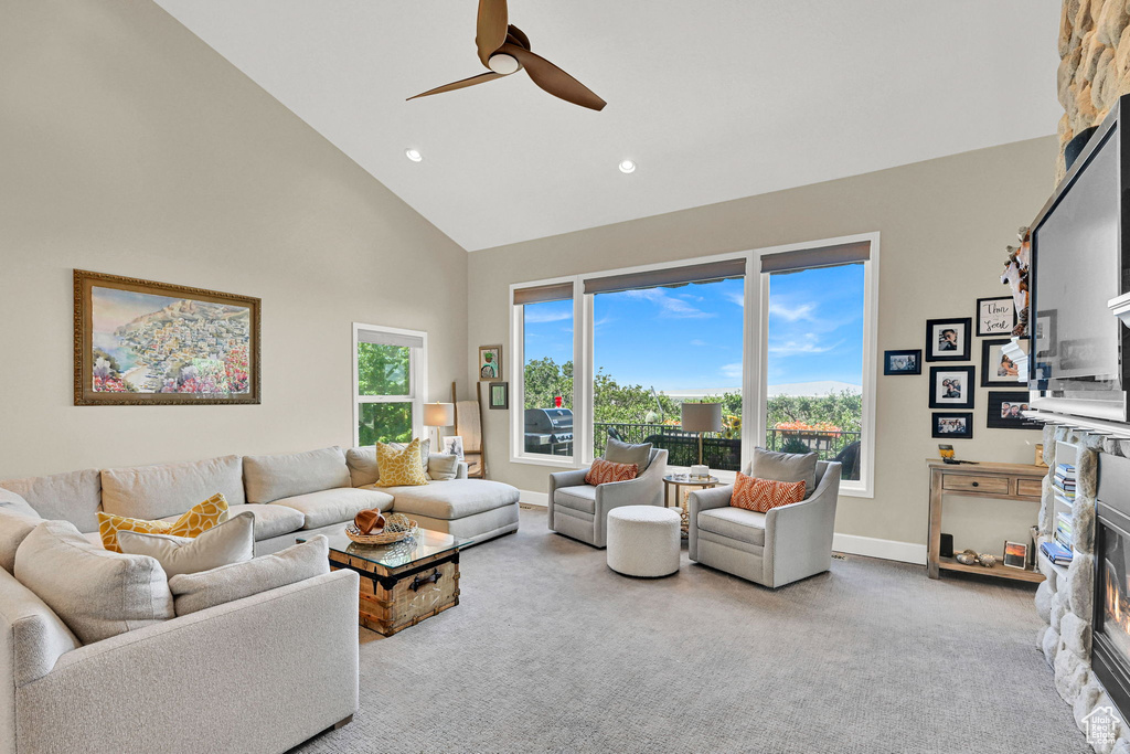Carpeted living room with high vaulted ceiling, ceiling fan, and recessed lighting