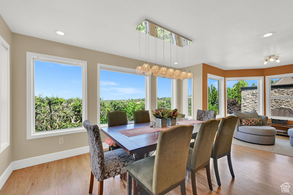 Dining room with plenty of natural light, a chandelier, wood finished floors, and recessed lighting