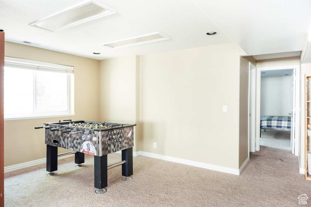 Rec room featuring attic access, carpet, and baseboards