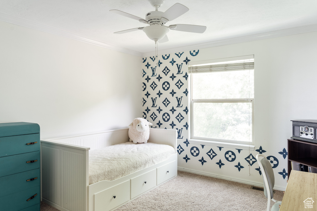 Bedroom with ornamental molding, carpet floors, wallpapered walls, and ceiling fan
